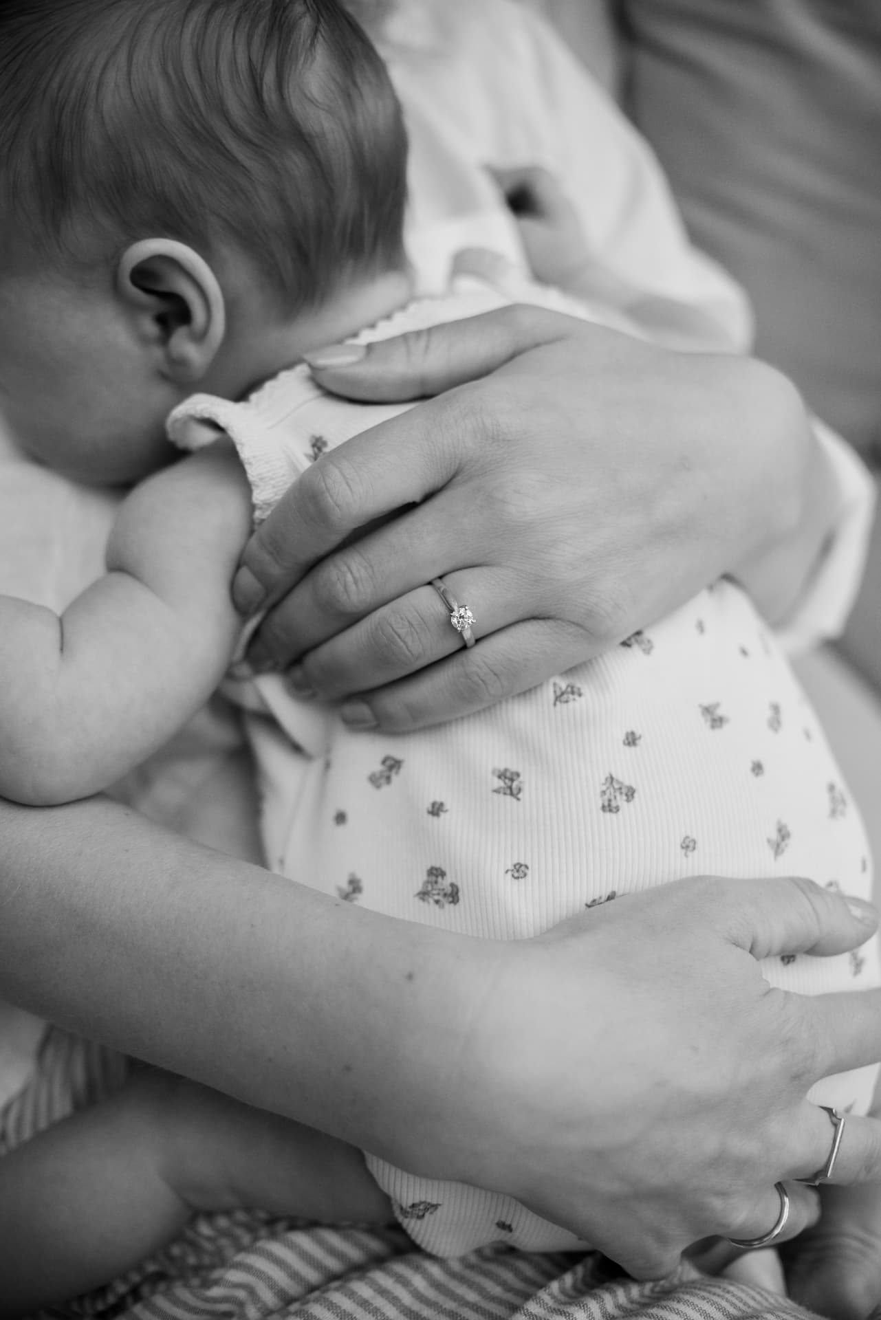 Black and white photograph of a baby sleeping in a mother's arms
