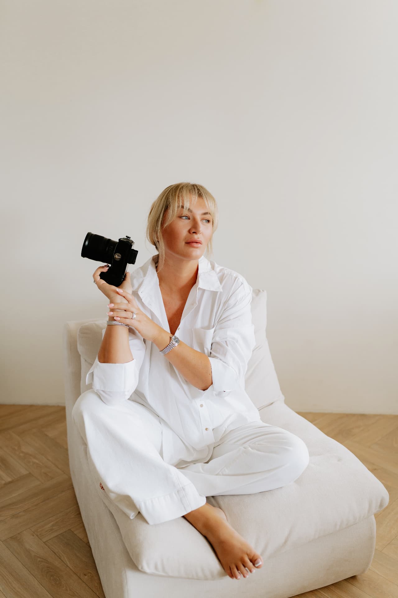 Robyn seated with her camera in a white shirt